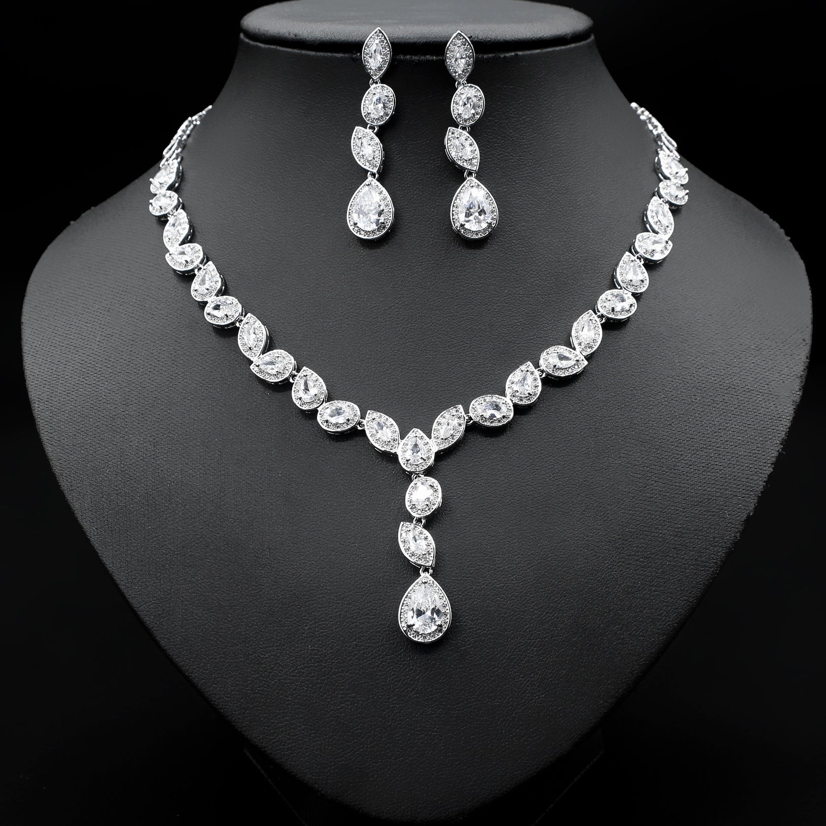 a necklace and earrings set on a mannequin